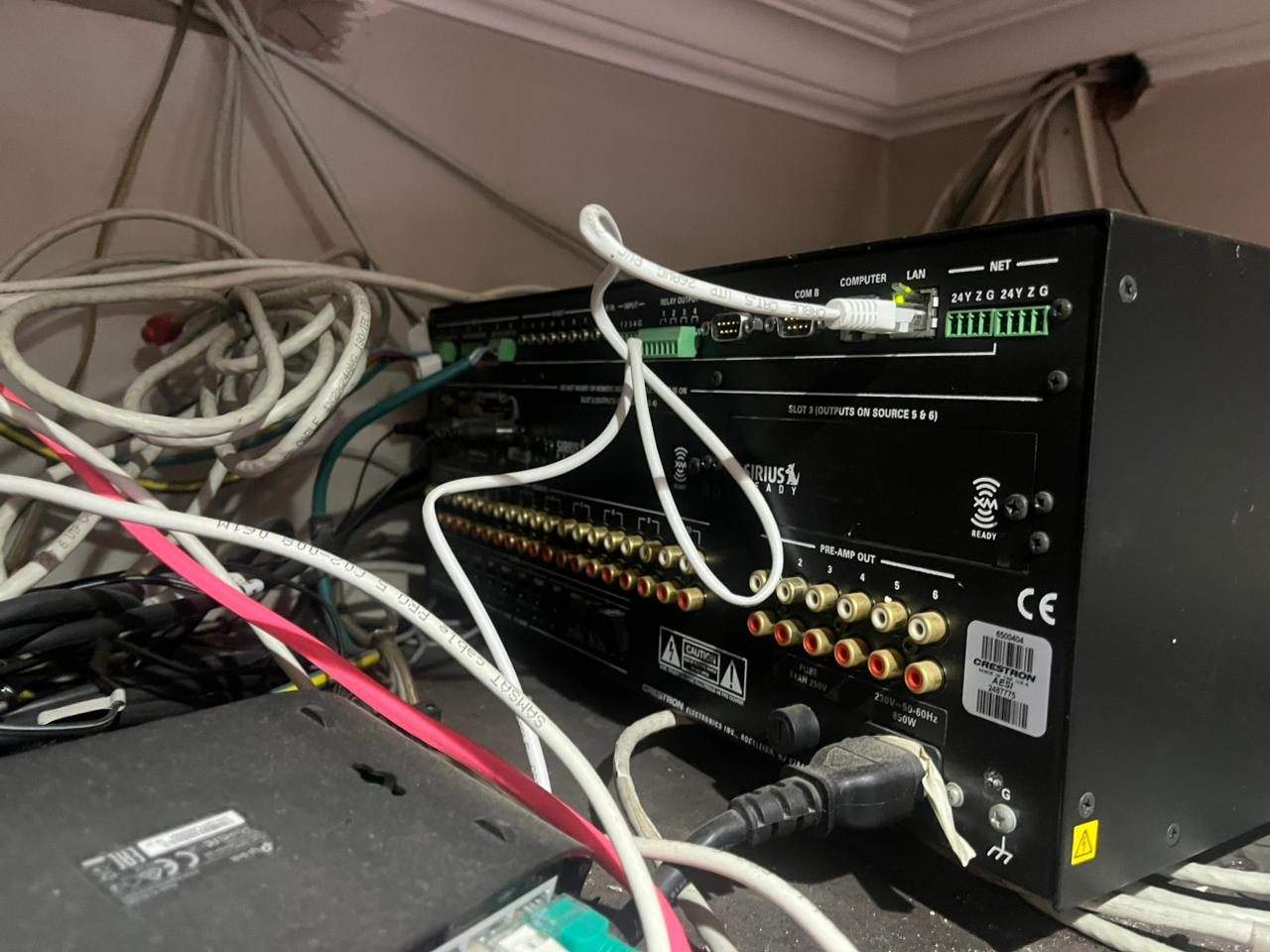 Legacy Crestron audio equipment with unmanaged cabling behind the rack